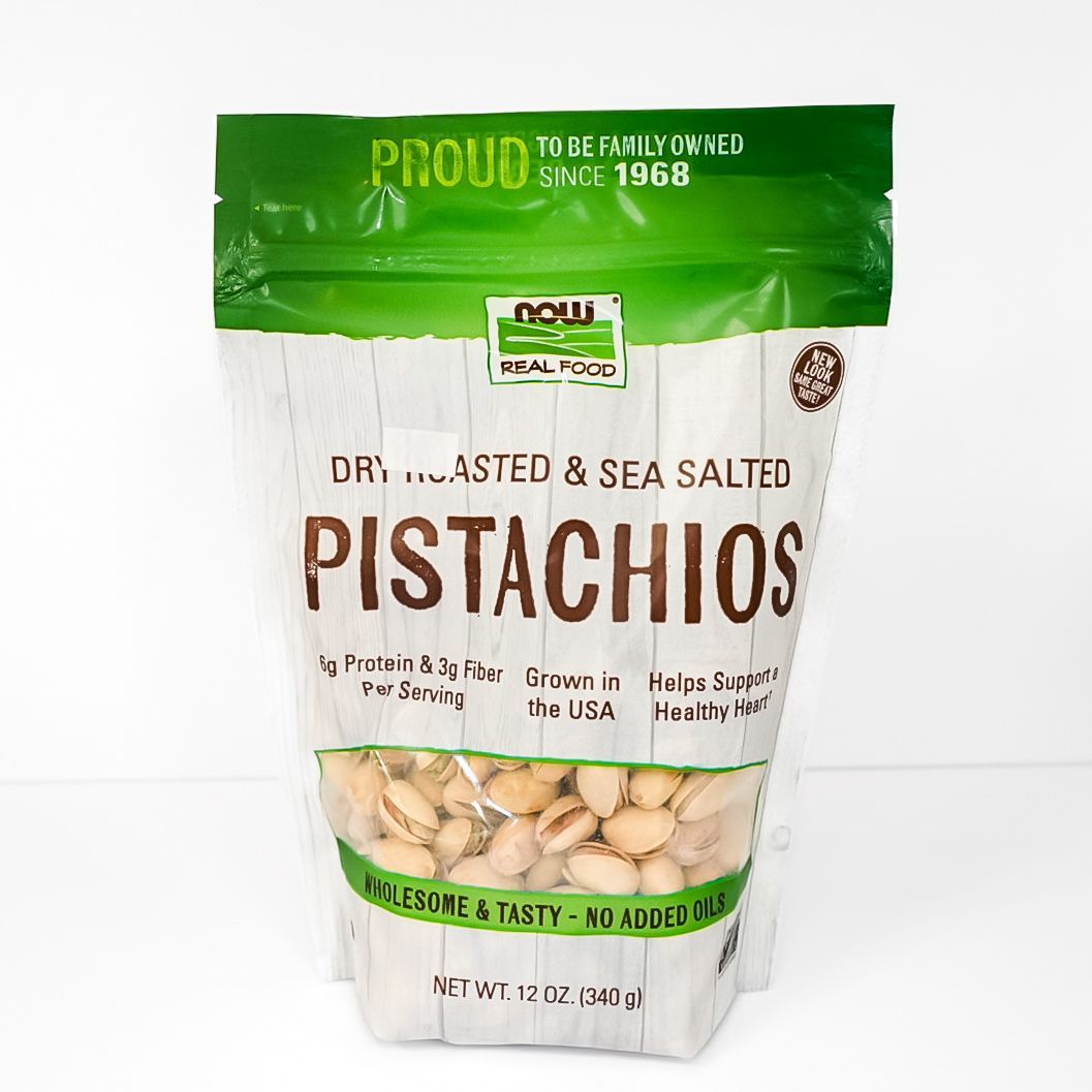 Green and white bag of dry roasted, sea salted pistachios on a white background