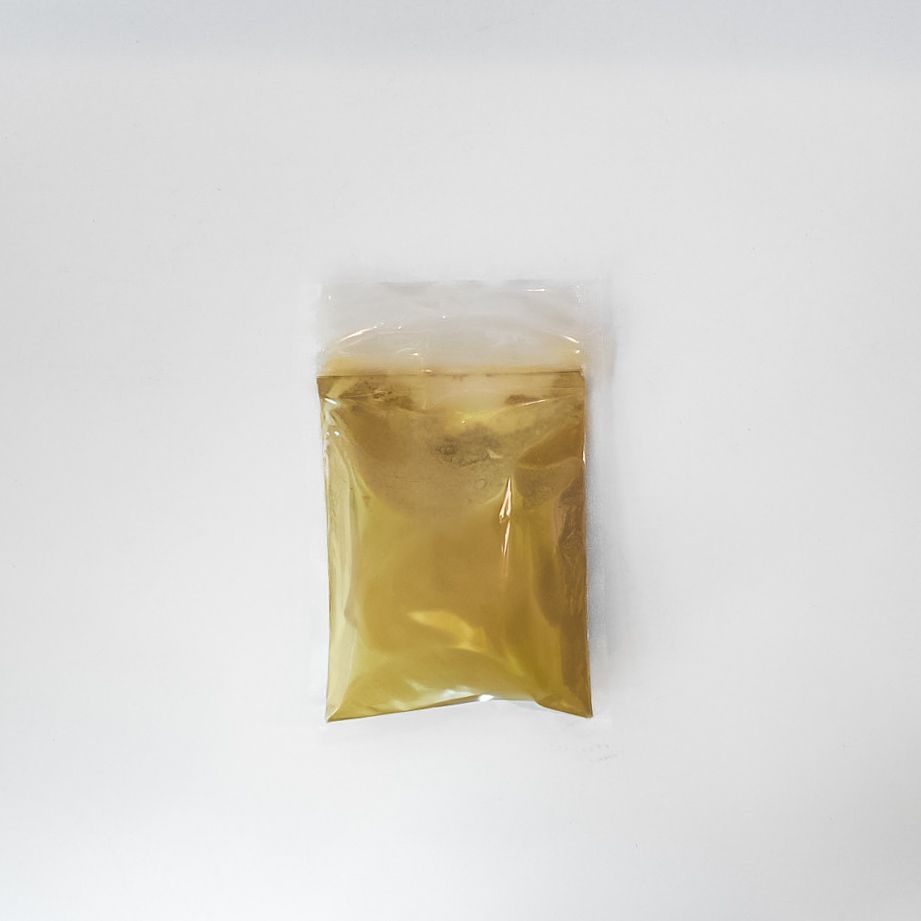Small clear plastic bag of yellow dandelion root powder with a bright label on a white background