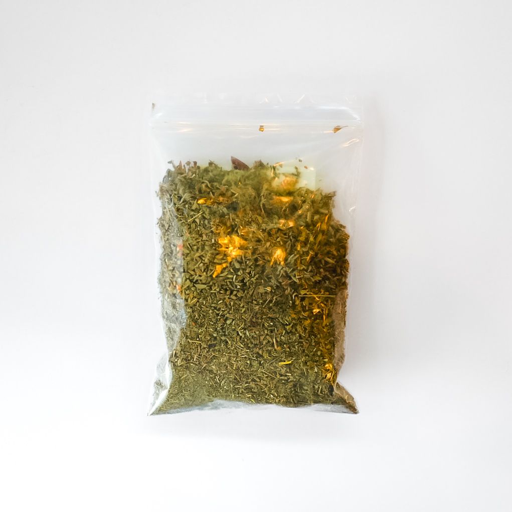 Clear bag of dried herbs with a bright yellow label on a white background