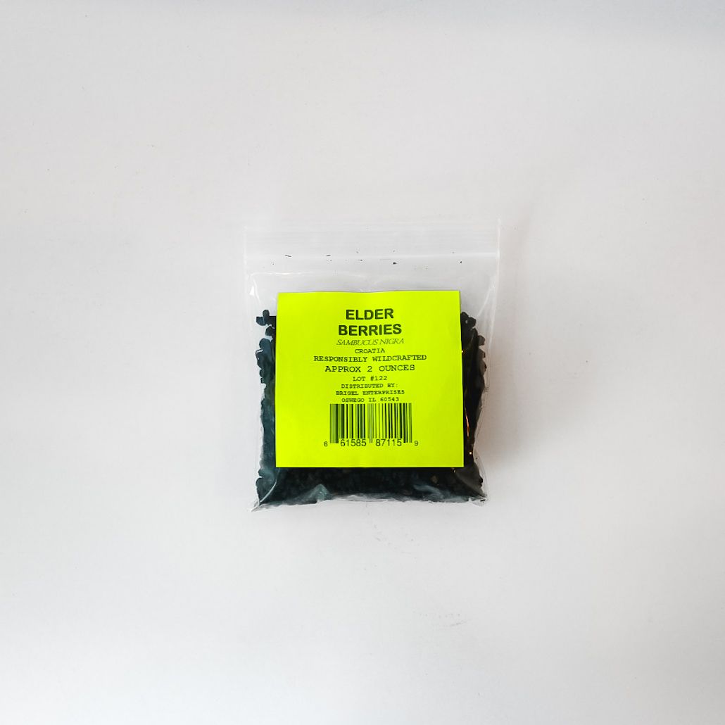 Small clear bag of dark green dried herbs with a bright yellow label on a white background