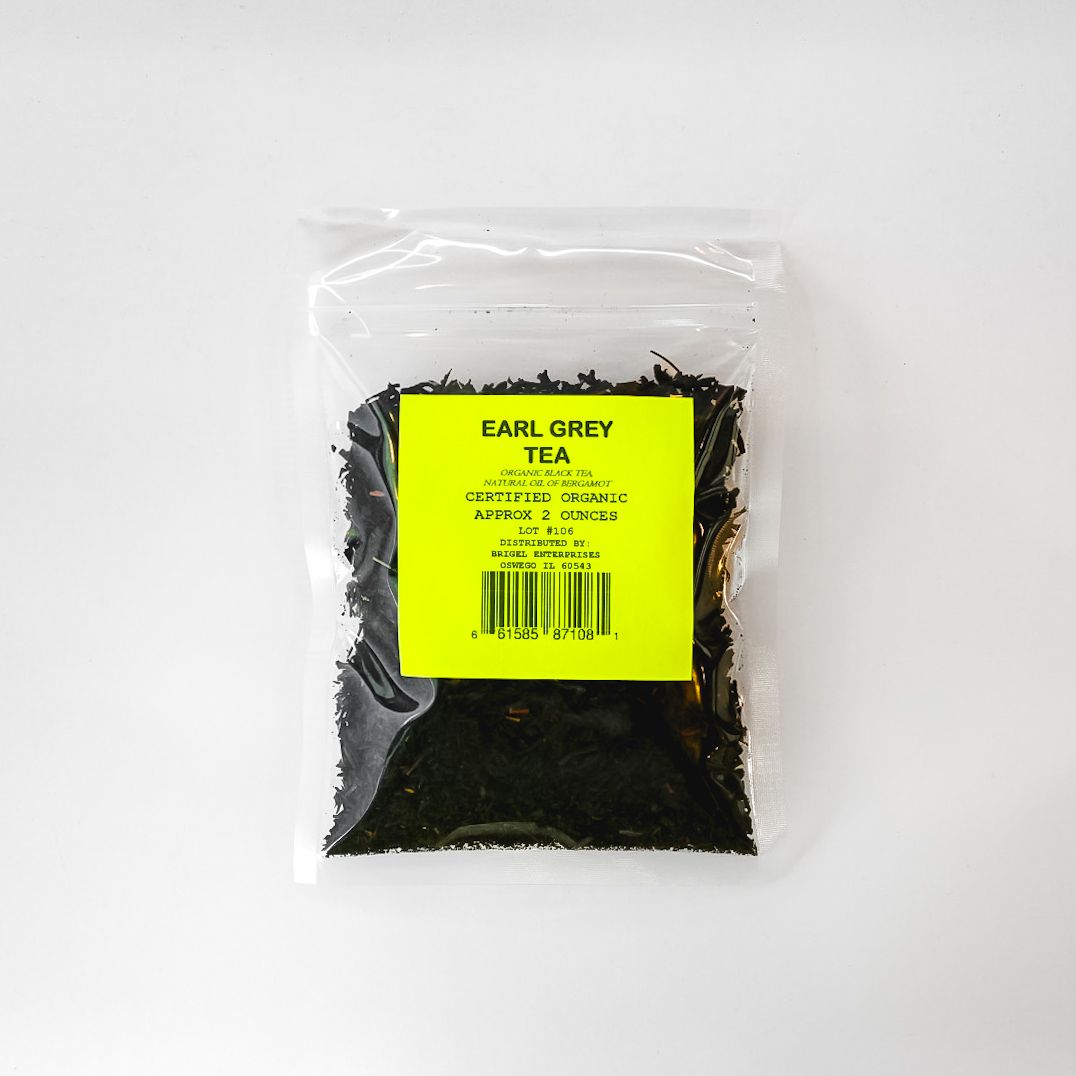 Clear plastic bag of Earl Grey tea leaves with a yellow label on a white background