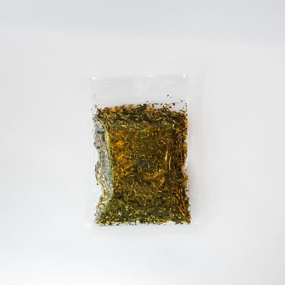 Small clear plastic bag of dried herbs with a bright yellow label on a white background