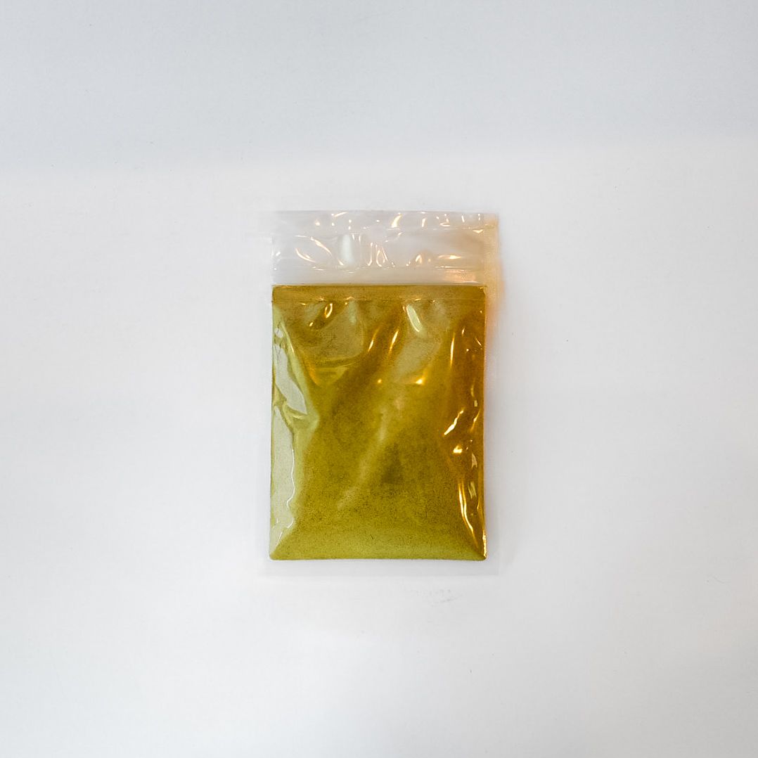 Small clear bag of yellow powder with a bright green label on a white background