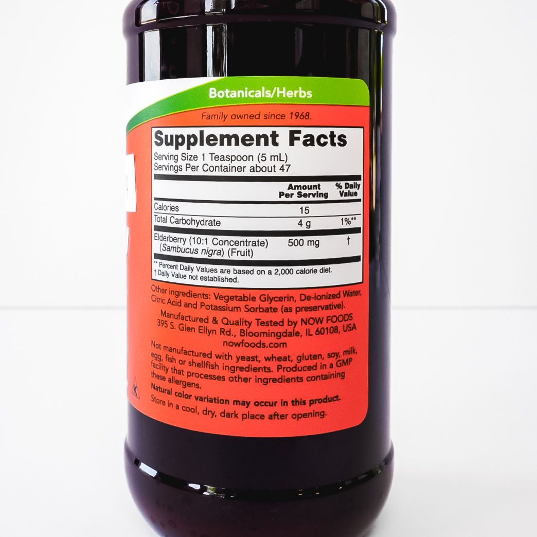 Bottle of NOW Elderberry Liquid supplement with red label and white cap on a plain background