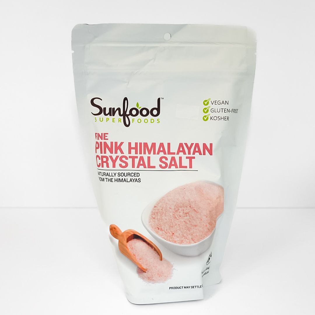 Sunfood pink Himalayan crystal salt in a white stand-up pouch with bowl and spoon illustration