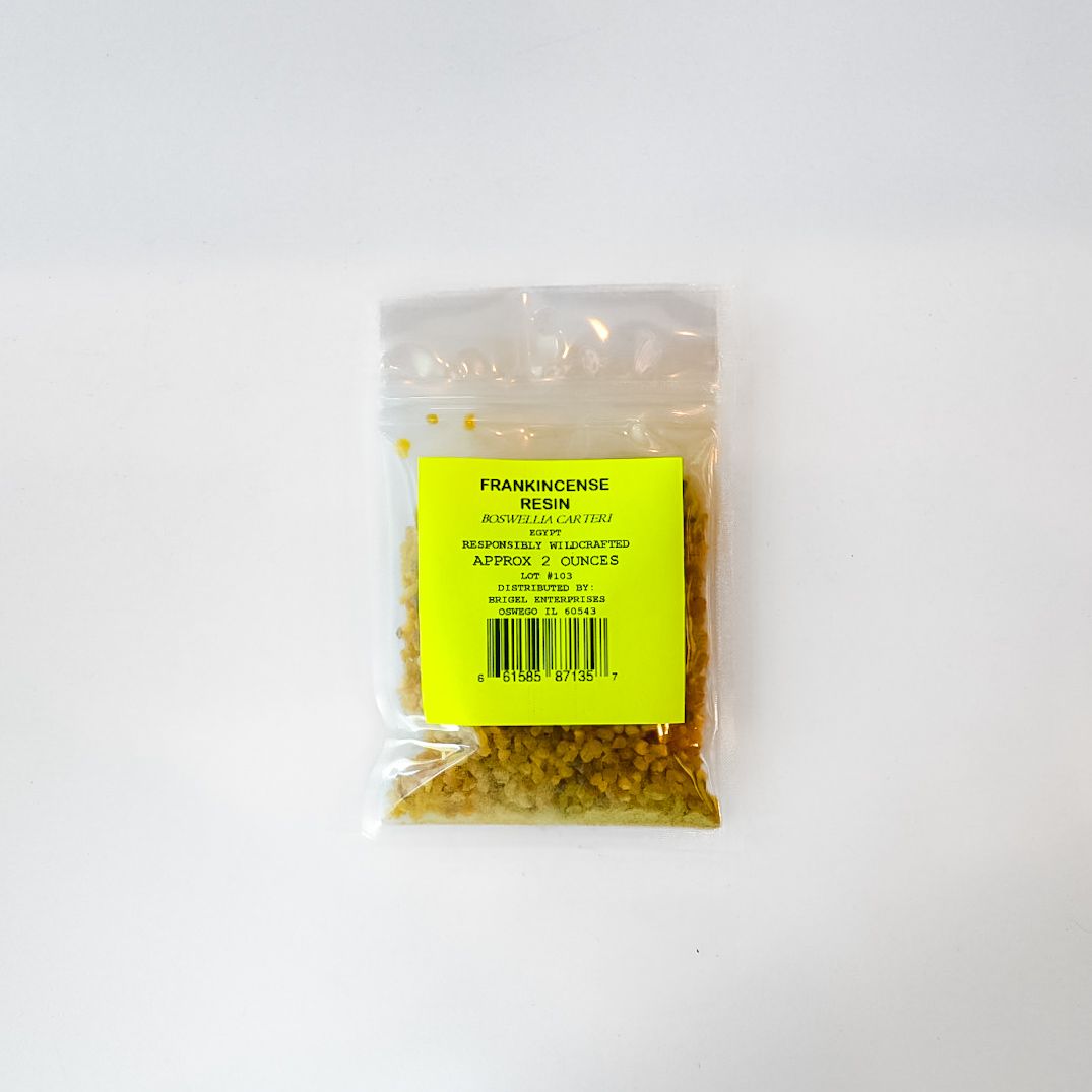 Clear plastic bag of dried yellow plant material with a bright green label on a white background
