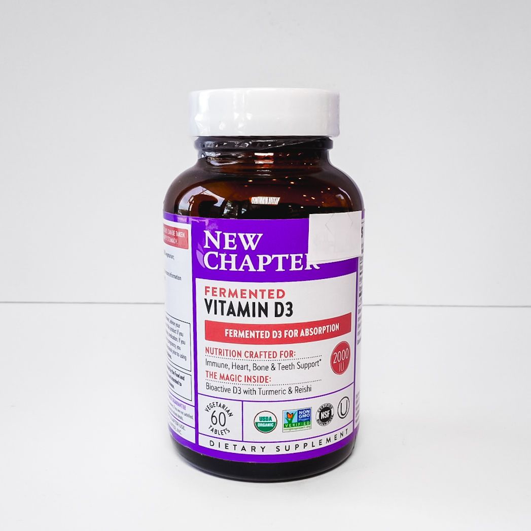 Brown vitamin D3 supplement bottle with white cap and purple label on a white background