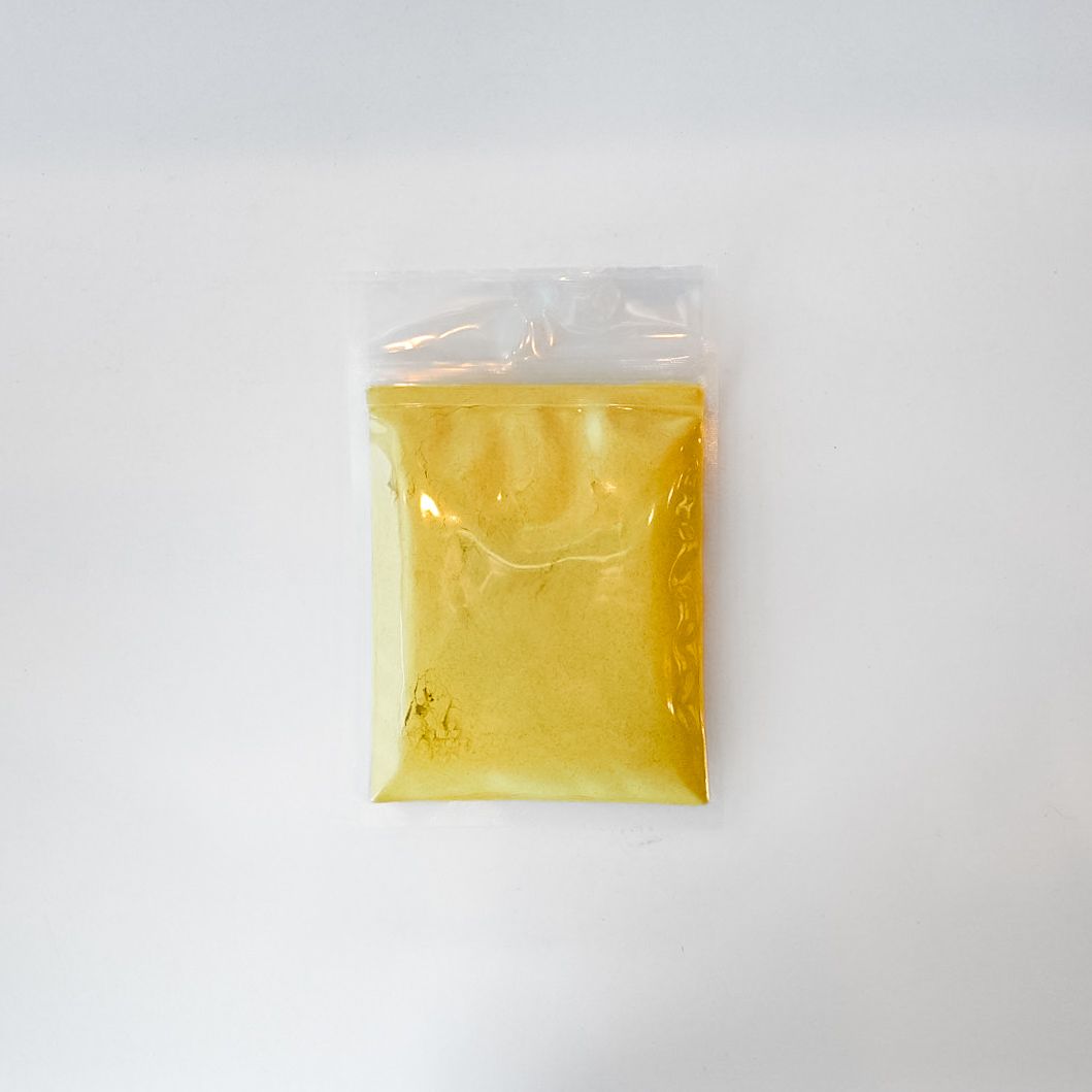 Small clear plastic bag of yellow powder with a bright yellow label on a white background