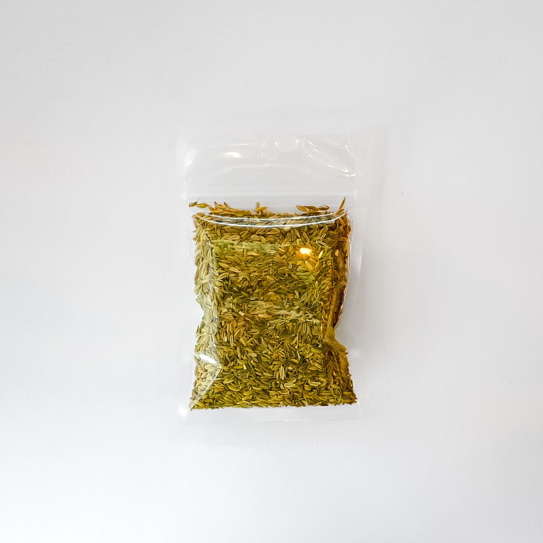 Small clear plastic bag of yellow-green dried herbs with a bright green label on a white surface