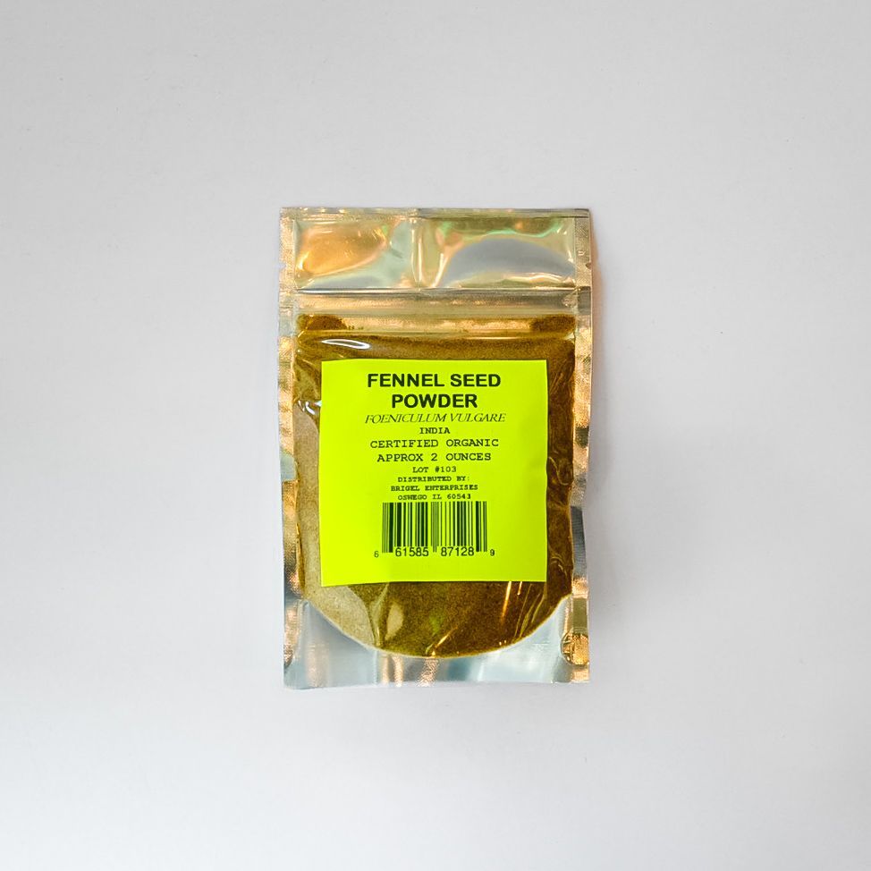 Small clear plastic packet of fennel seed powder with a yellow label on a white background
