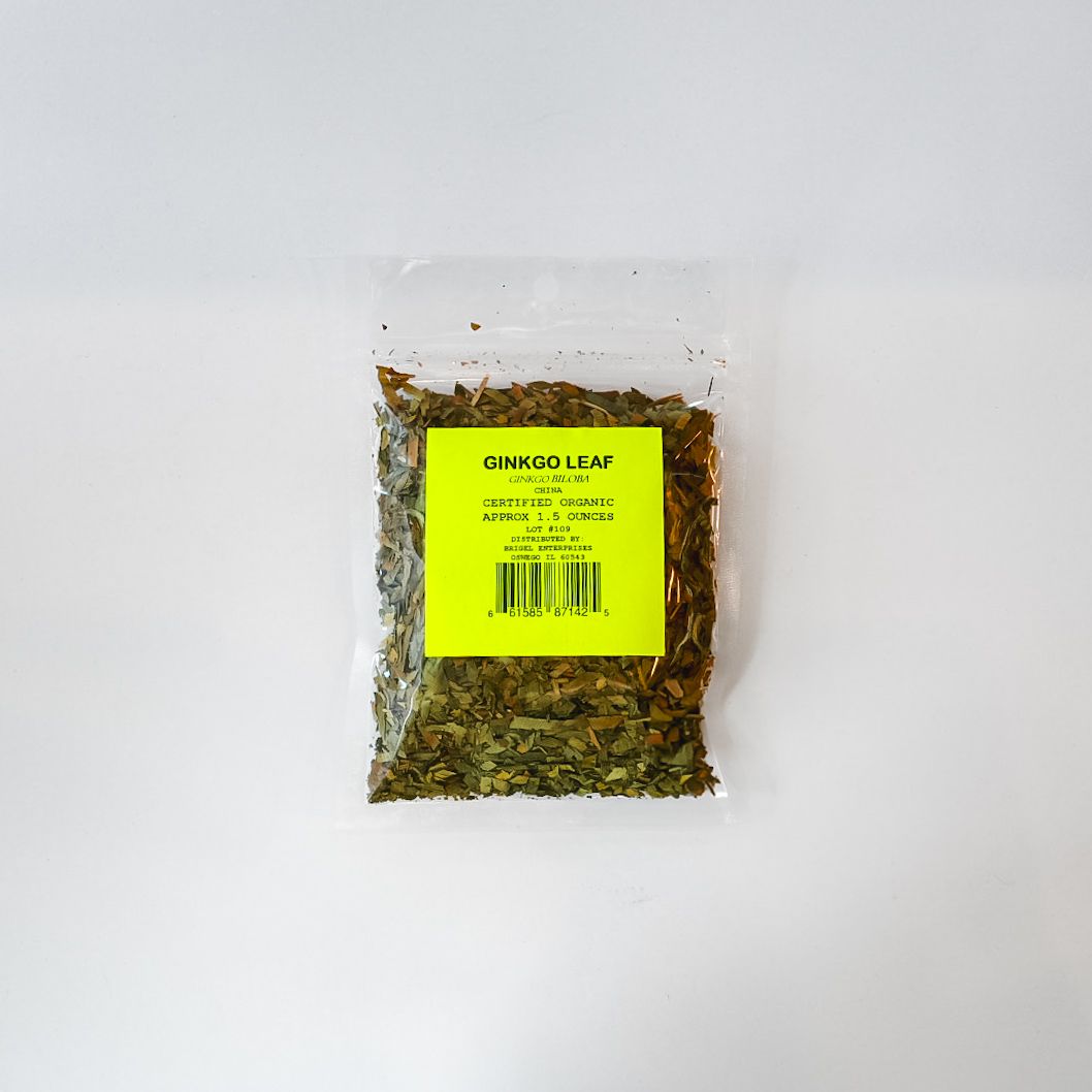 Small clear plastic bag of dried green herb with a bright yellow label on a white background