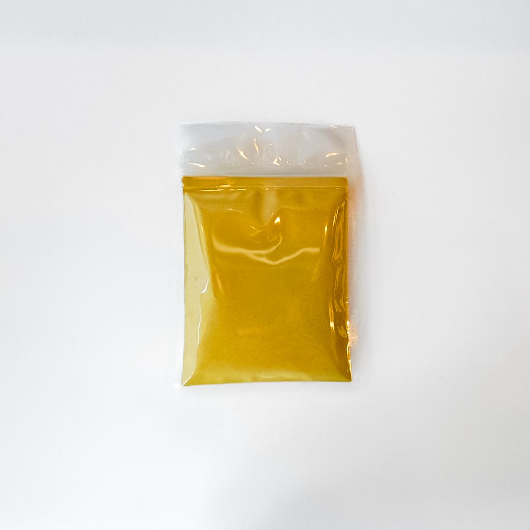 Clear plastic bag of yellow ginger root powder on a white background