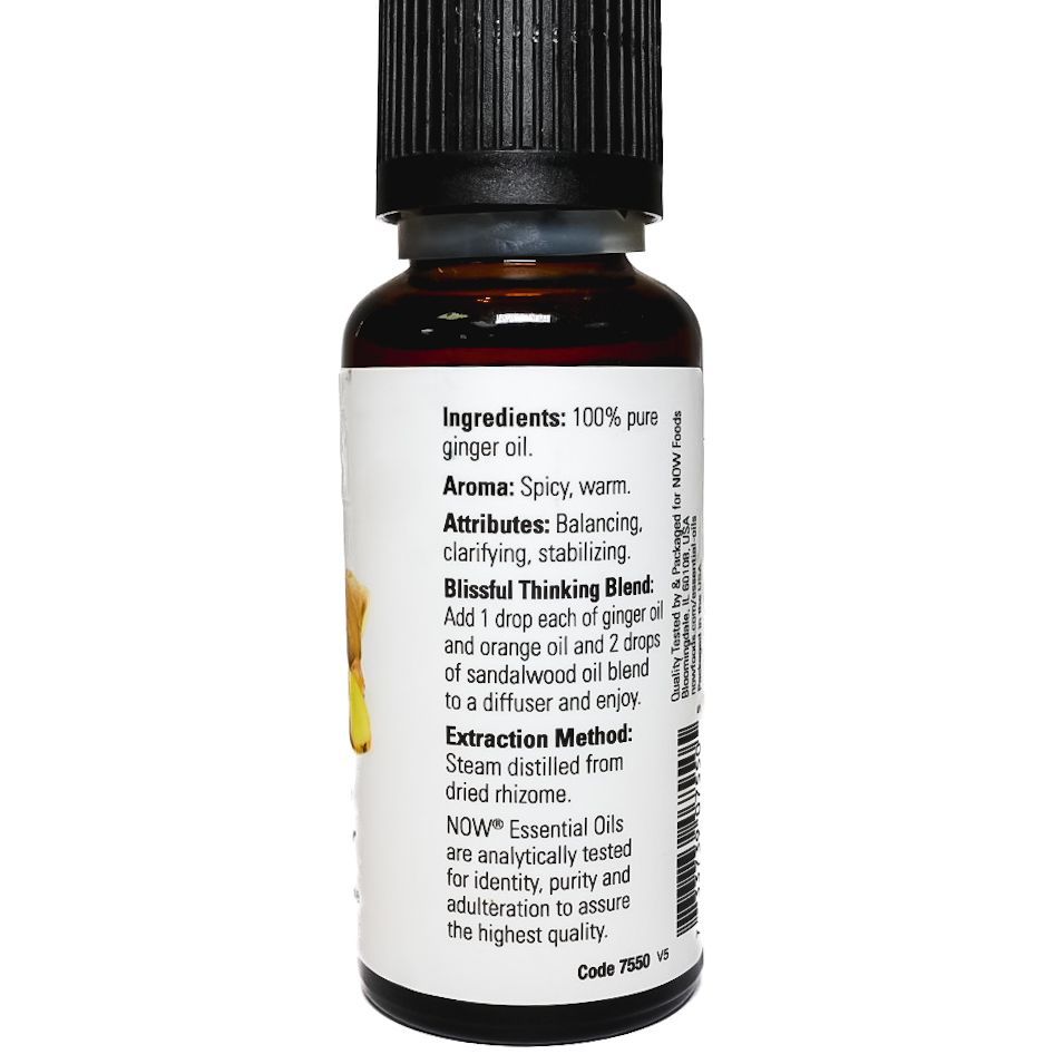 Bottle of ginger essential oil with black cap and yellow ginger root label on a white background