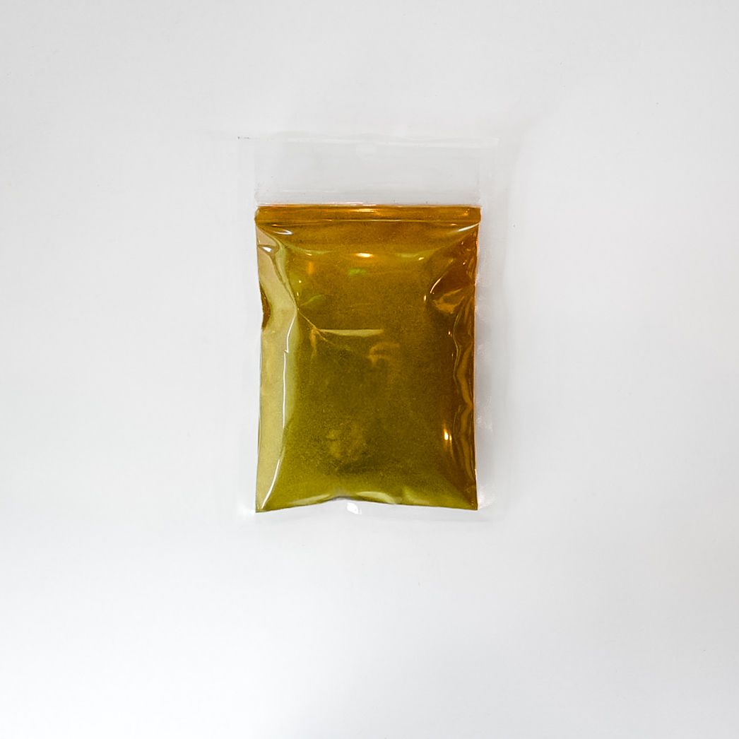 Clear bag of green powder with a bright yellow label on a white background