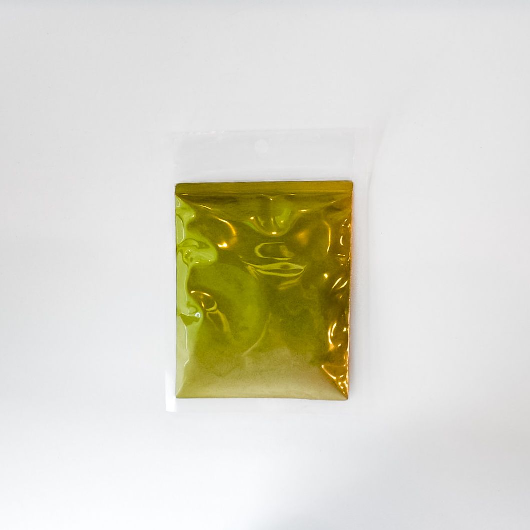 Small clear plastic bag of yellow-green powder with a bright green label on a white background
