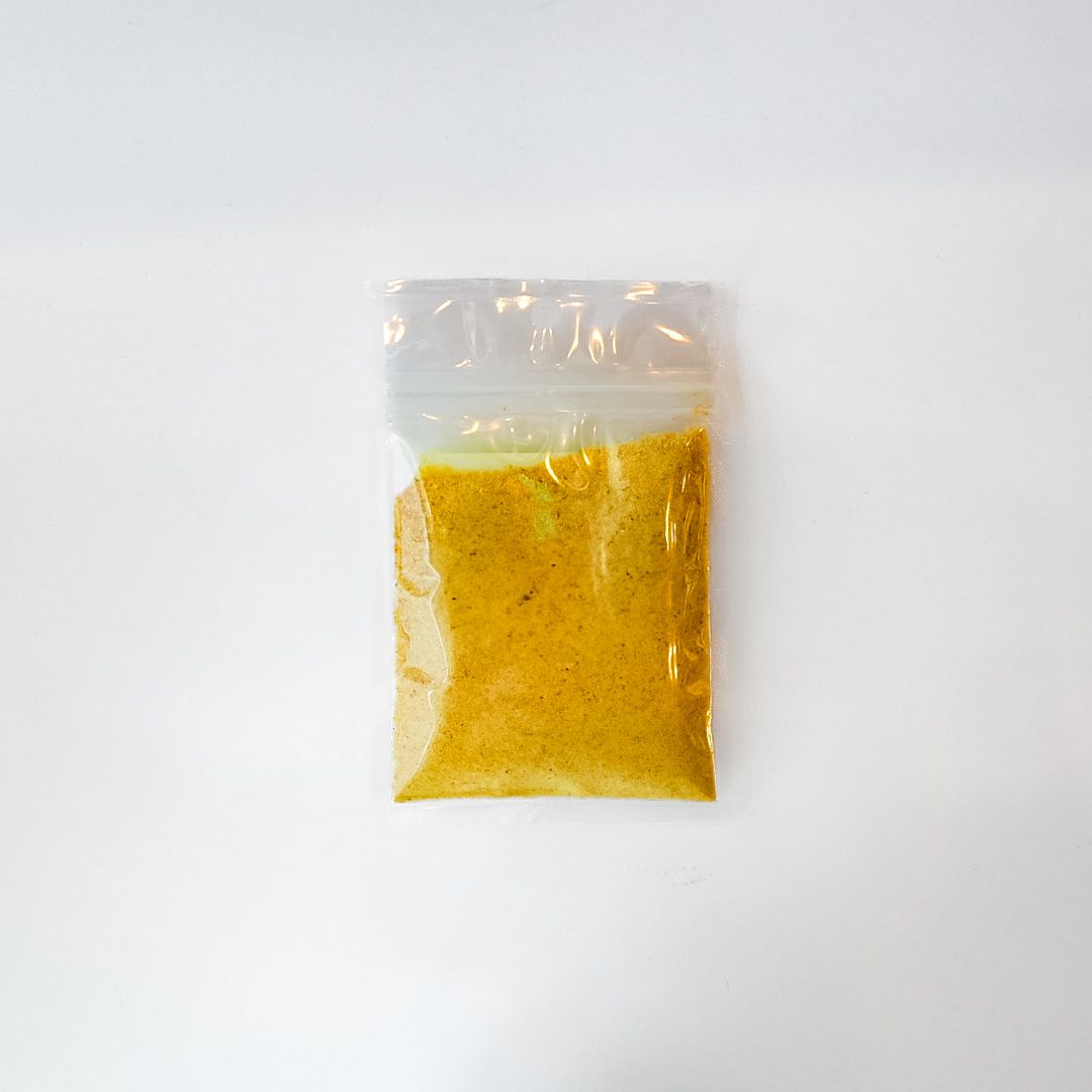 Clear plastic bag of yellow garlic granules with a bright green label on a white background