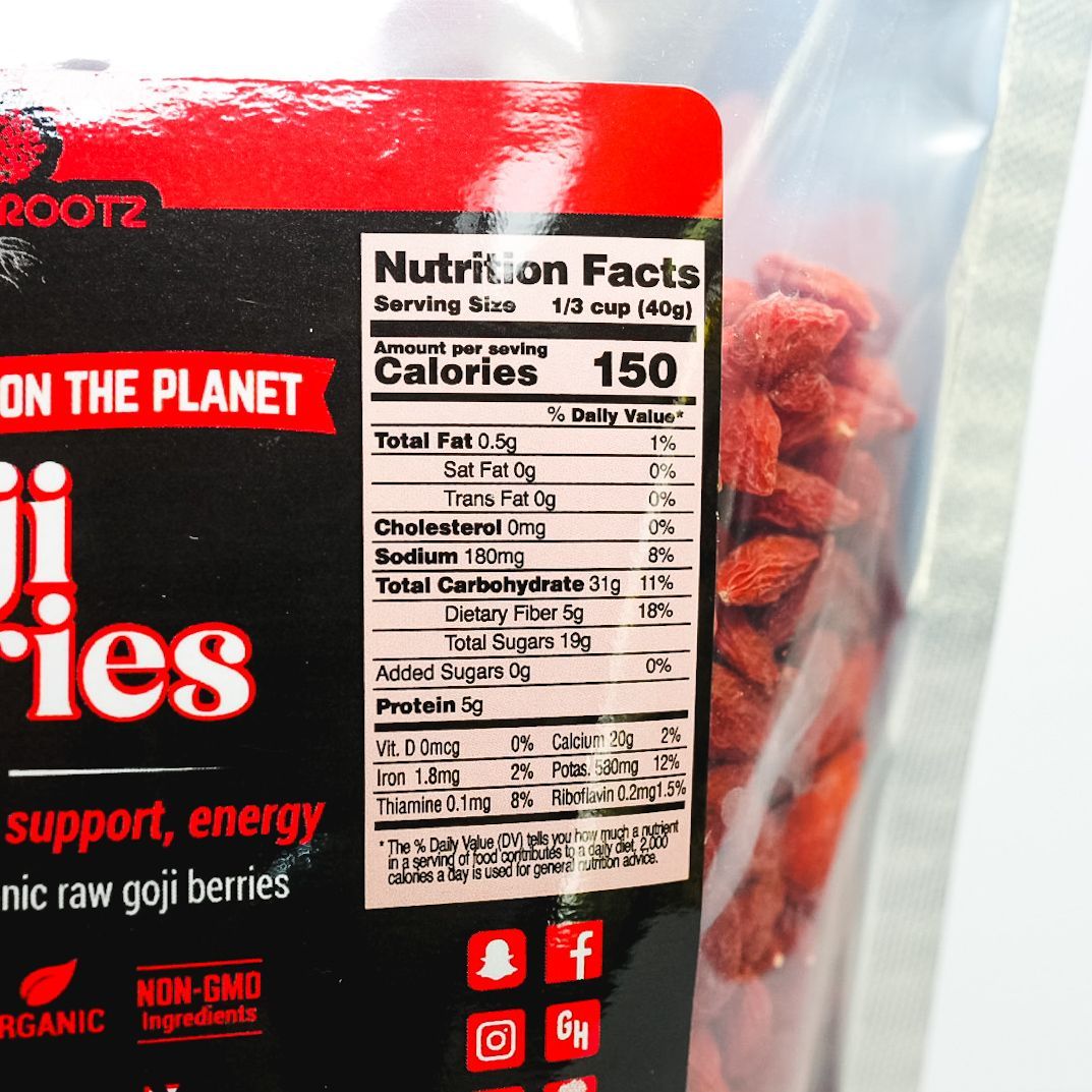 Clear plastic pouch of dried red chili flakes on a white background