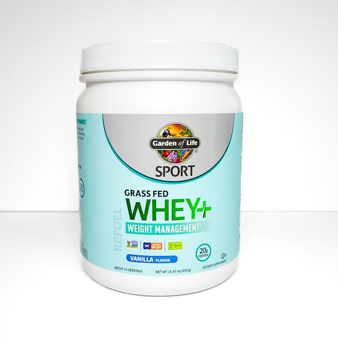 White Grass Fed Whey+ protein supplement jar with teal label on a white background