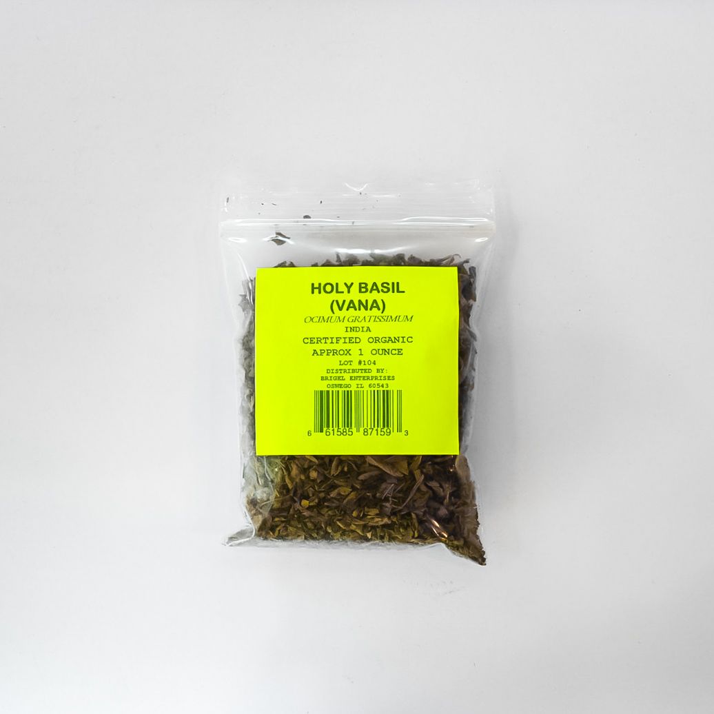 Clear plastic bag of dried holy basil with a bright yellow label on a white background