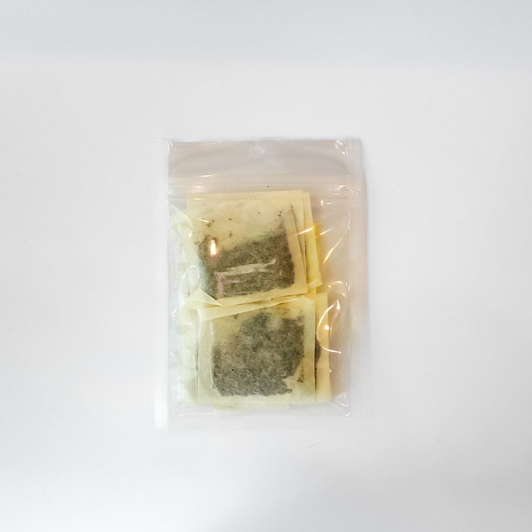 Plastic bag of loose-leaf tea with a bright yellow label on a white background