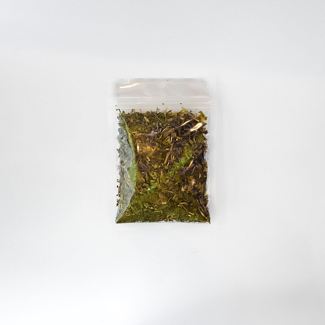 Clear plastic bag of dried herbs with a bright yellow label on a white background