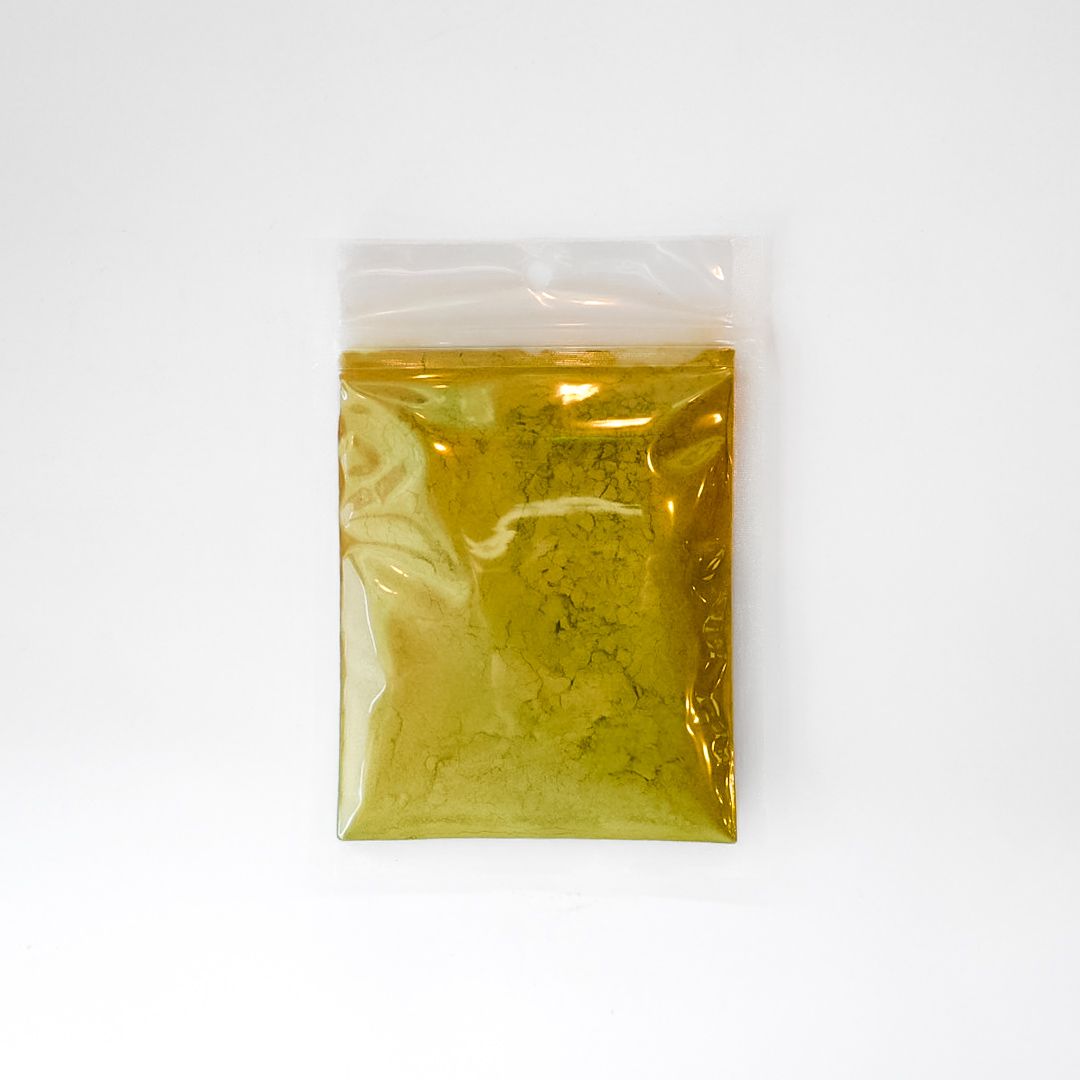 Clear plastic bag of yellow-brown powder with a neon green label and barcode on a white background