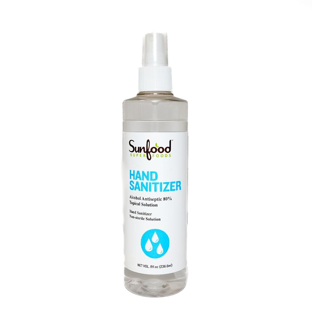 Clear plastic spray bottle of Sunfood hand sanitizer with blue-and-white label on a white background