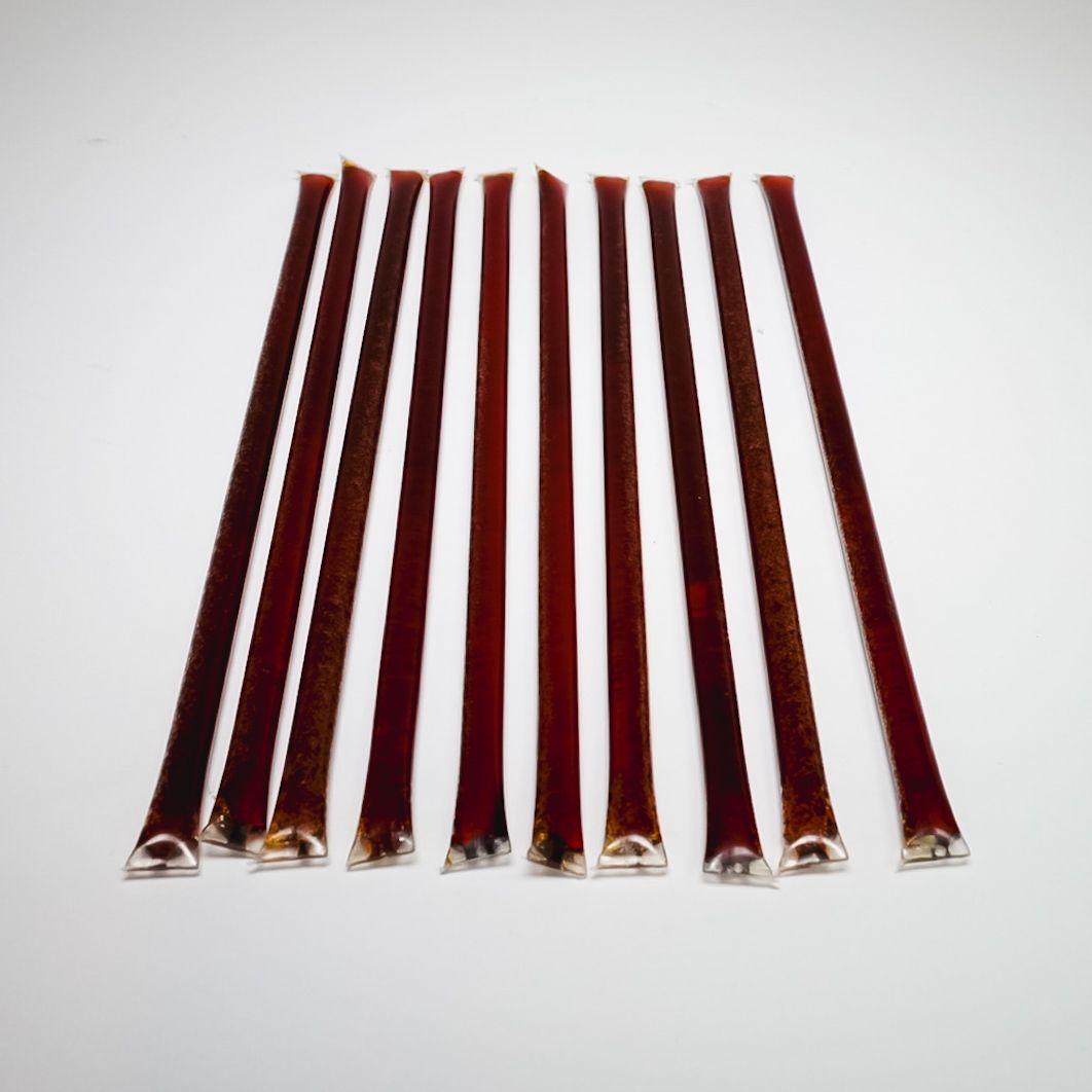 Jar filled with red and black pencils against a white background