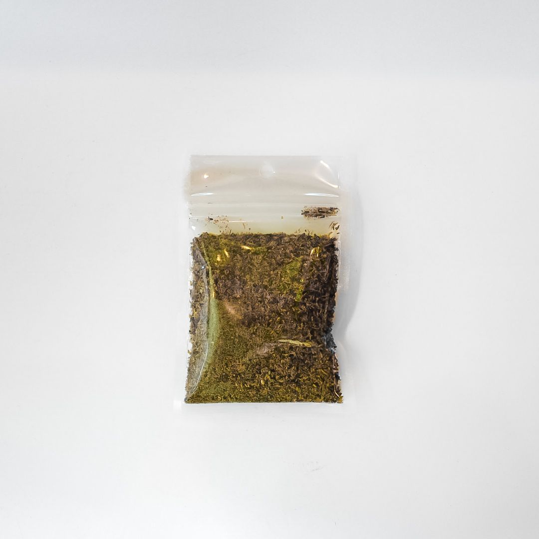 Small clear plastic bag of bright yellow-green moss on a white background.