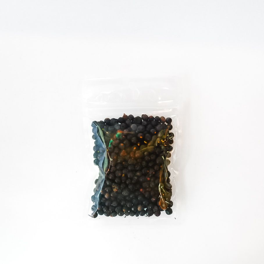Bag of dried juniper berries with bright yellow label on a white background