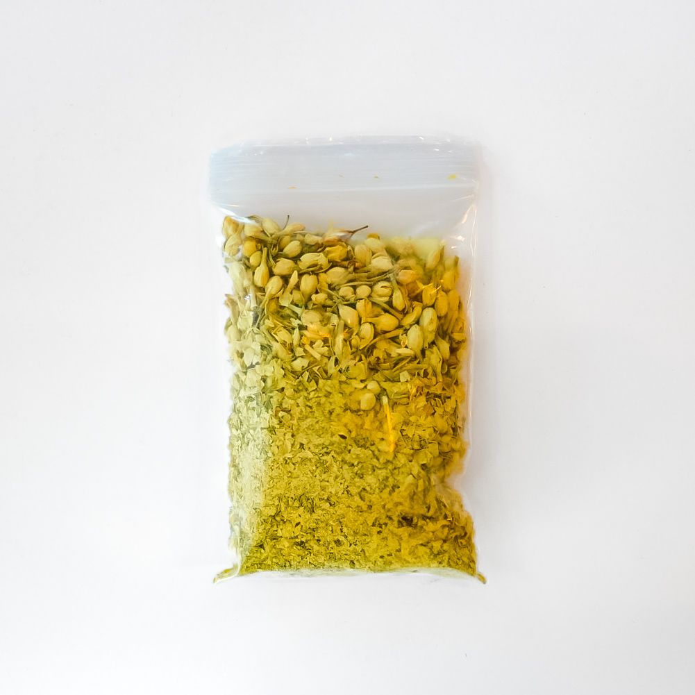 Clear bag of dried flowers with bright yellow label on a white background