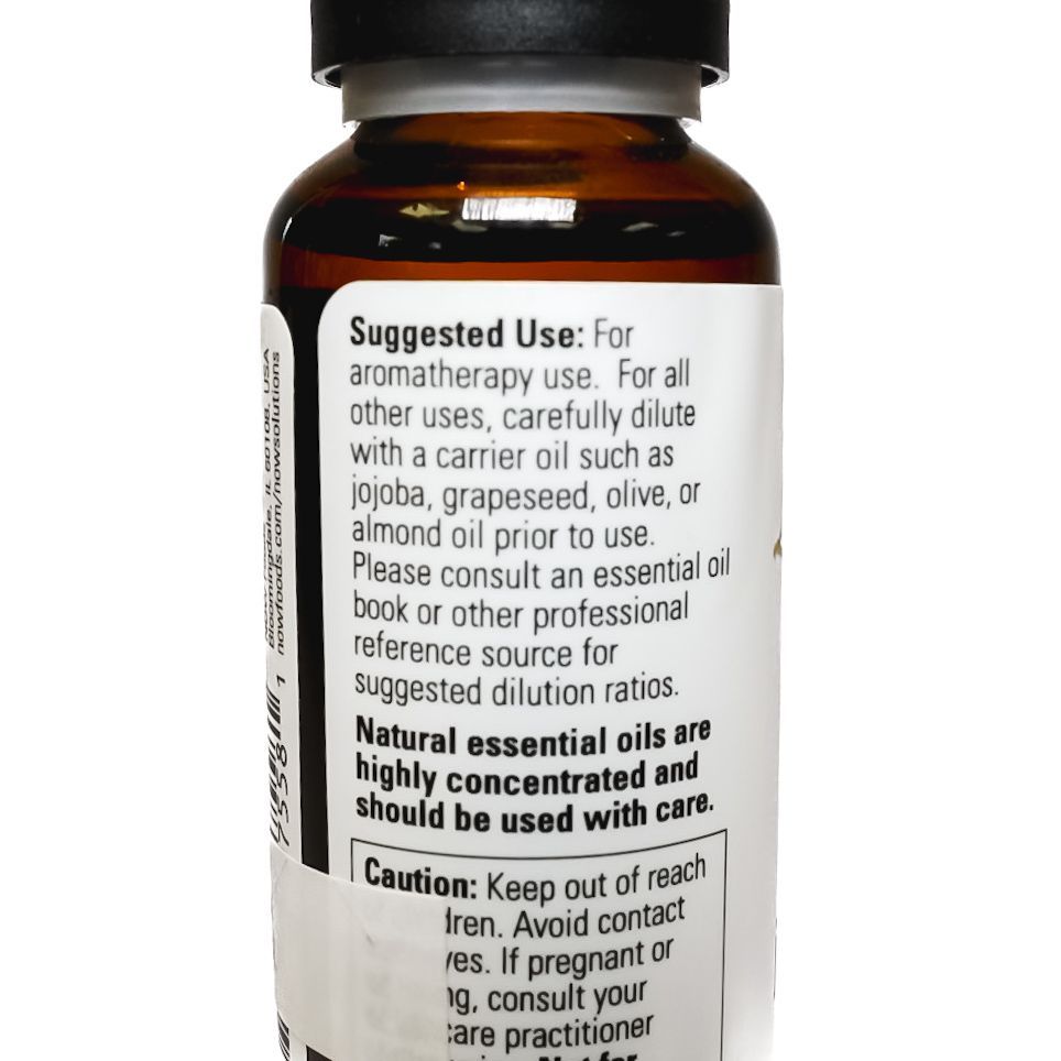 Small brown NOW brand anise berry essential oil bottle with black cap on white background