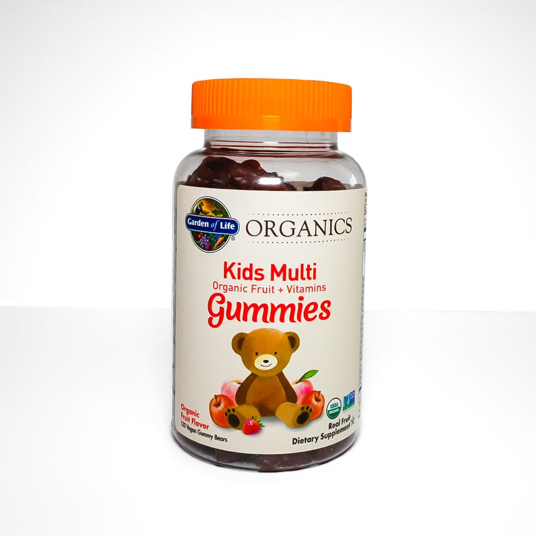 Bottle of Organics Kids Multi Gummies with orange cap and teddy bear label, on a white background