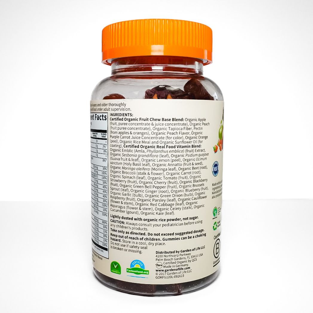 Bottle of Organics Kids Multi Gummies with orange cap and teddy bear label, on a white background