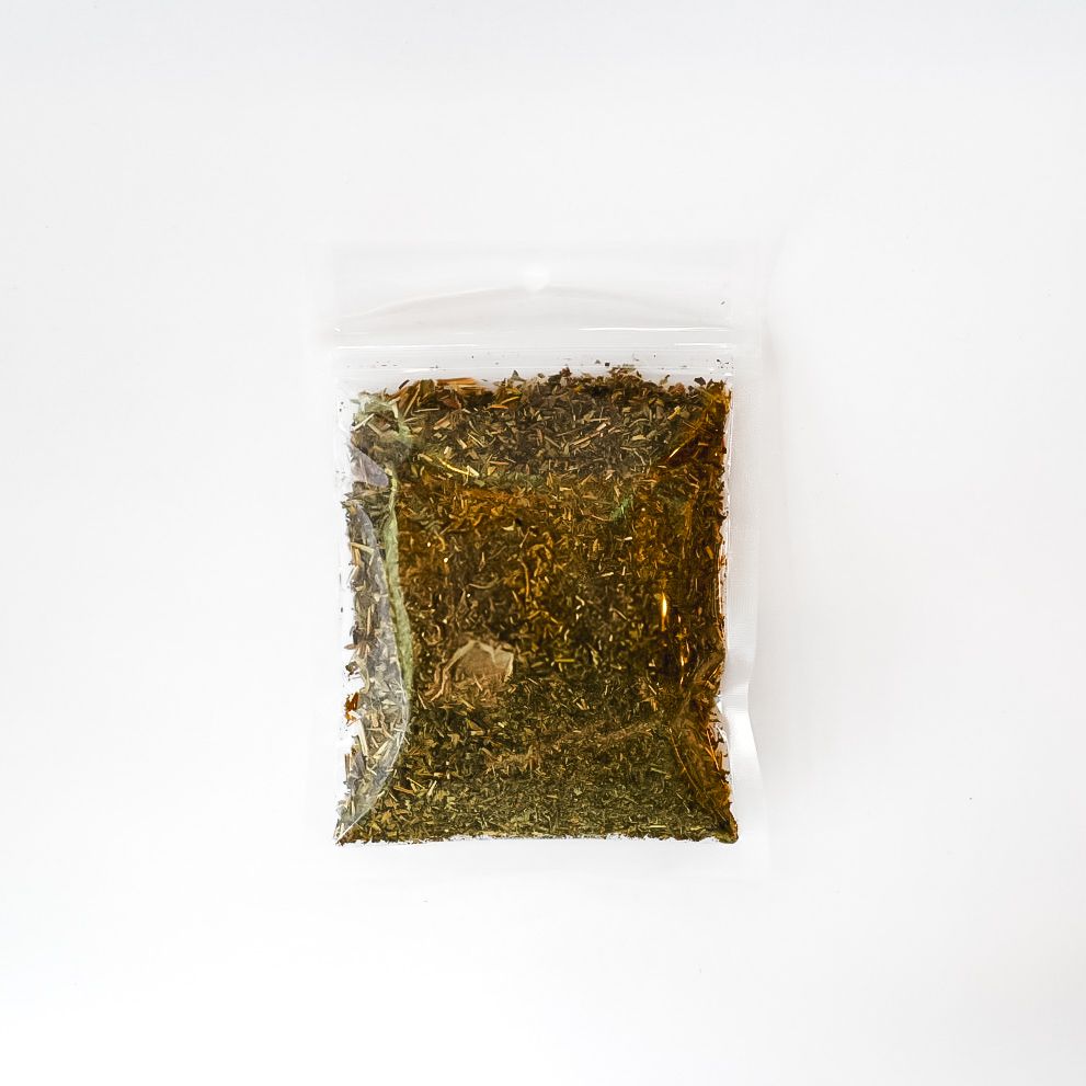 Clear plastic bag of dried lemon balm with a bright yellow label on a white background