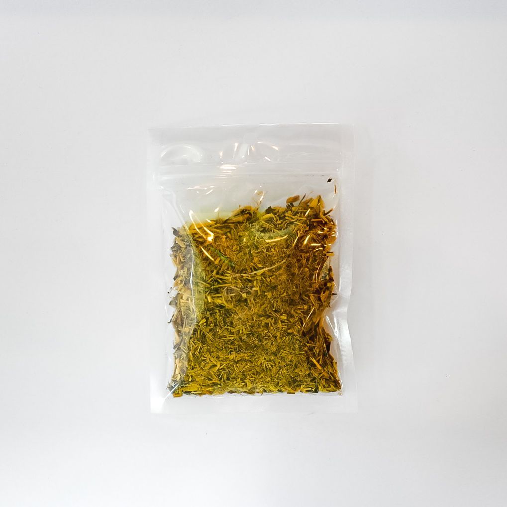 Clear plastic bag of dried licorice root with a bright yellow label on a white background