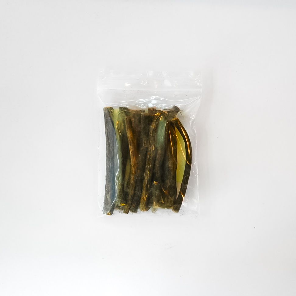 Bag of licorice root sticks with a bright yellow label on a white background