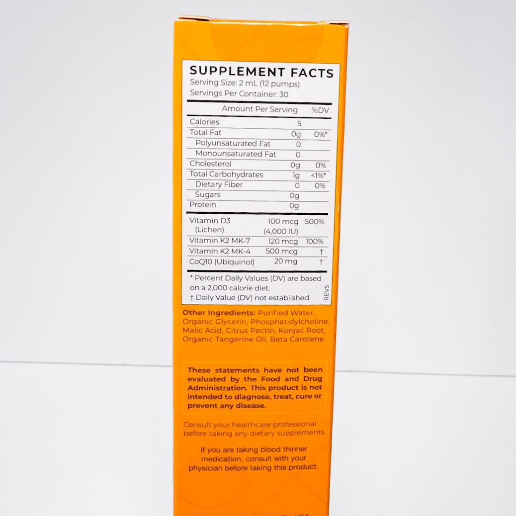 Orange skincare product box with black pump bottle on a white background