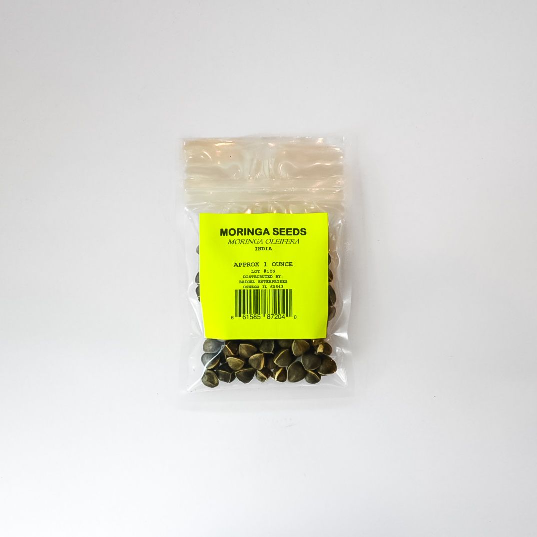 Small clear packet of moringa seeds with a bright yellow label on a white background