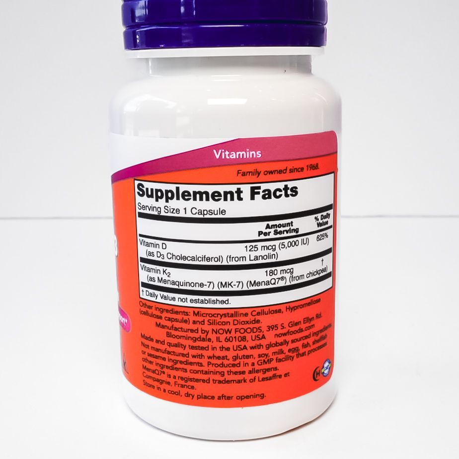 NOW Mega D-3 & MK-7 dietary supplement bottle with purple cap and orange label on white background