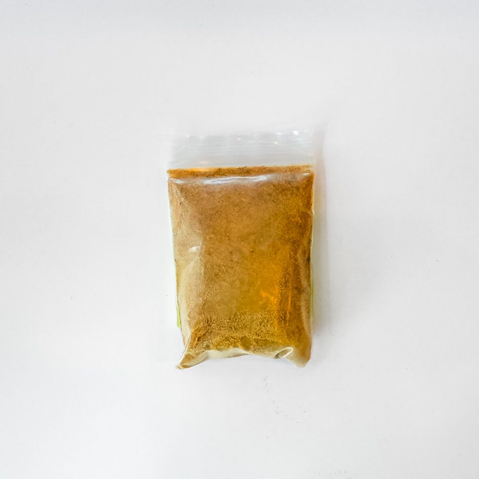 Clear jar of yellow myrrh gum powder with a bright green label on a white background