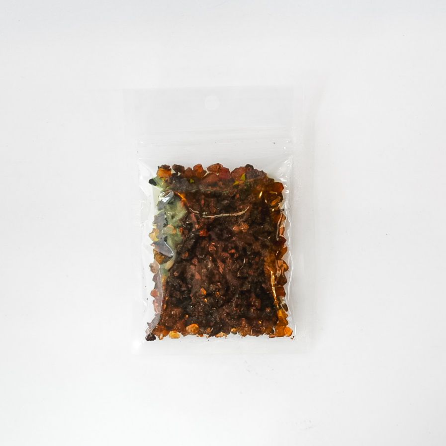 Small clear plastic bag of dried herbs with a bright yellow label on a white background