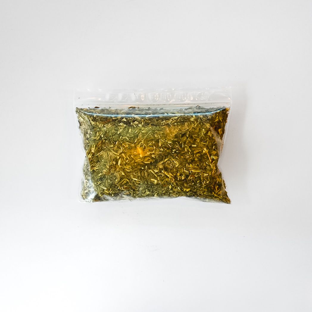 Plastic bag of dried herb or spice with bright yellow label and barcode on a white background