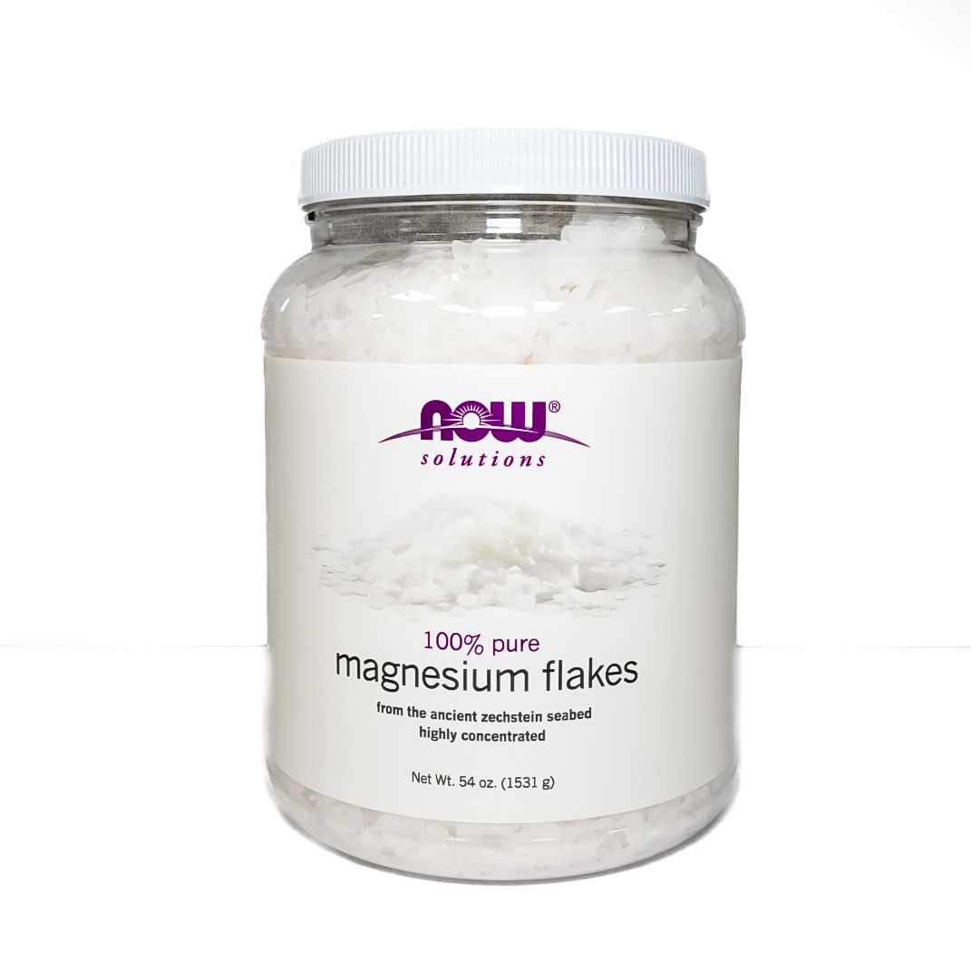 Jar of NOW Solutions magnesium flakes with white lid and label on a plain background