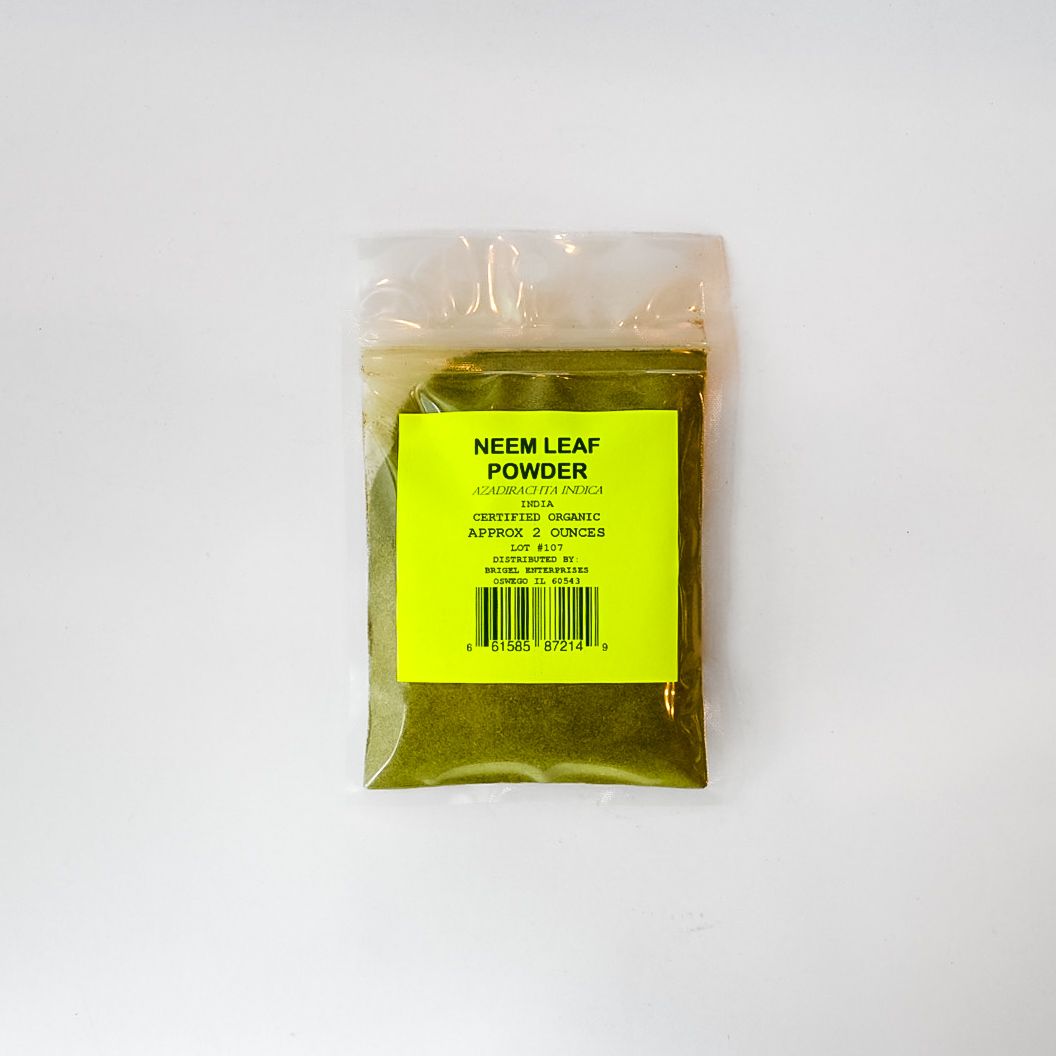 Small clear plastic bag of green leaf powder with a bright yellow label on a white background