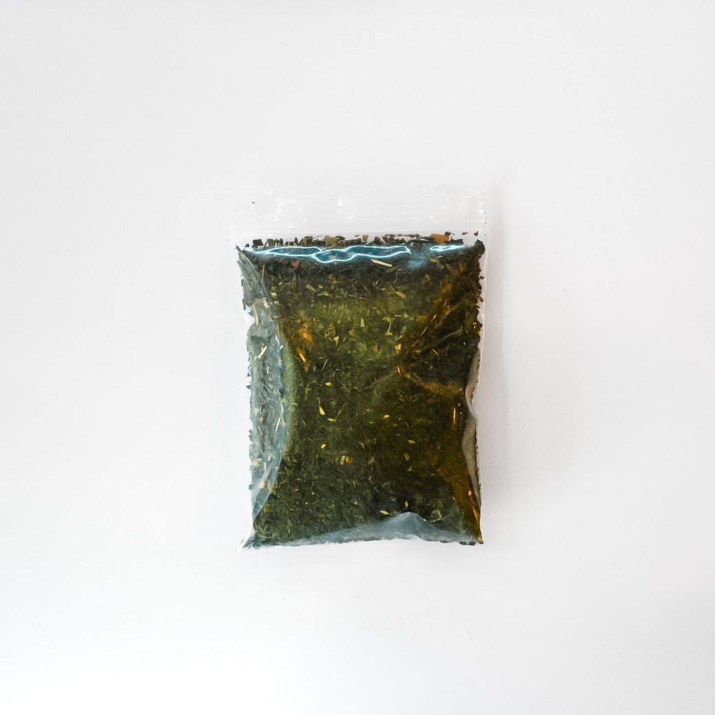 Small clear bag of dried nettle leaf with bright yellow label on white background