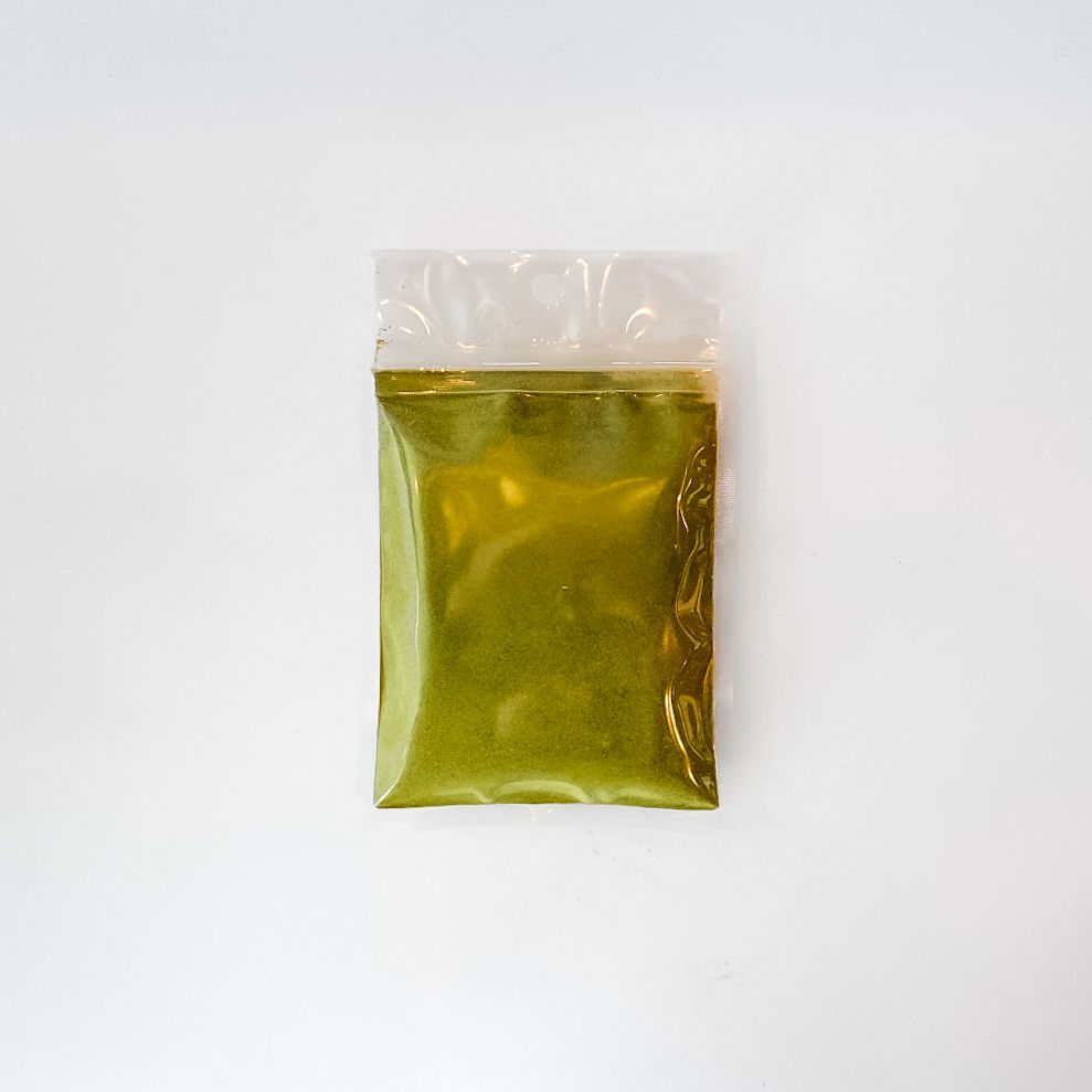 Small clear plastic bag of green leaf powder with a bright yellow label on a white background