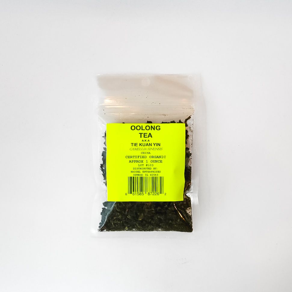 Clear plastic bag of Oolong tea with bright yellow label and loose tea leaves inside