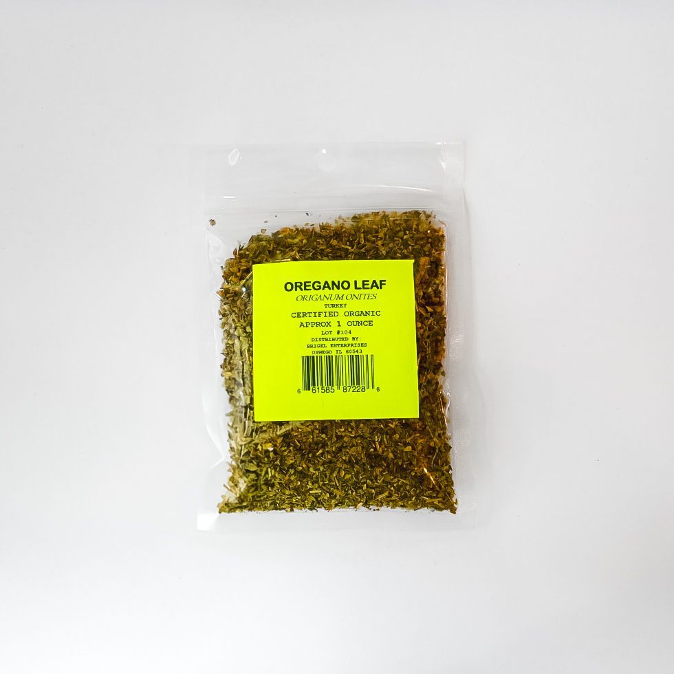 Clear plastic bag of dried oregano leaves with a bright yellow label on a white background