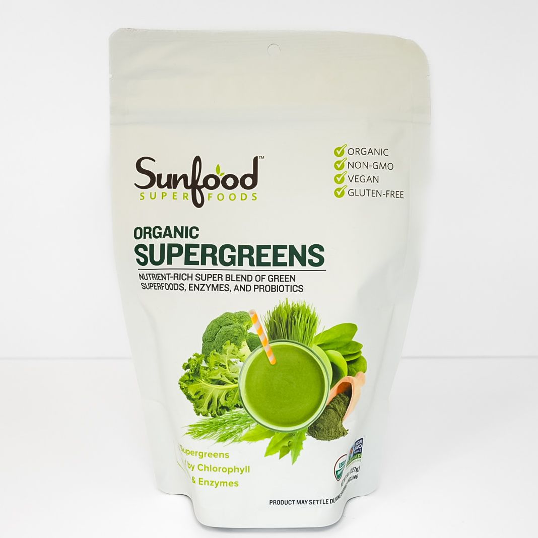 White pouch of Sunfood organic supergreens powder with green smoothie graphic